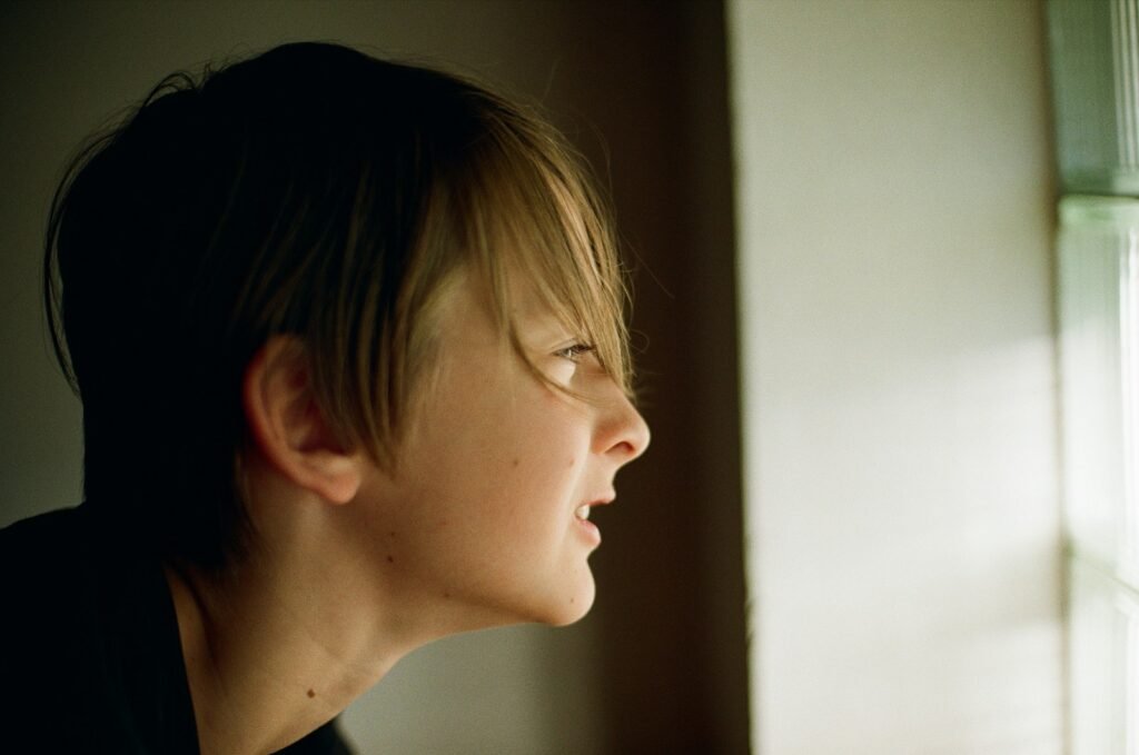 A woman looking out a window at the outside